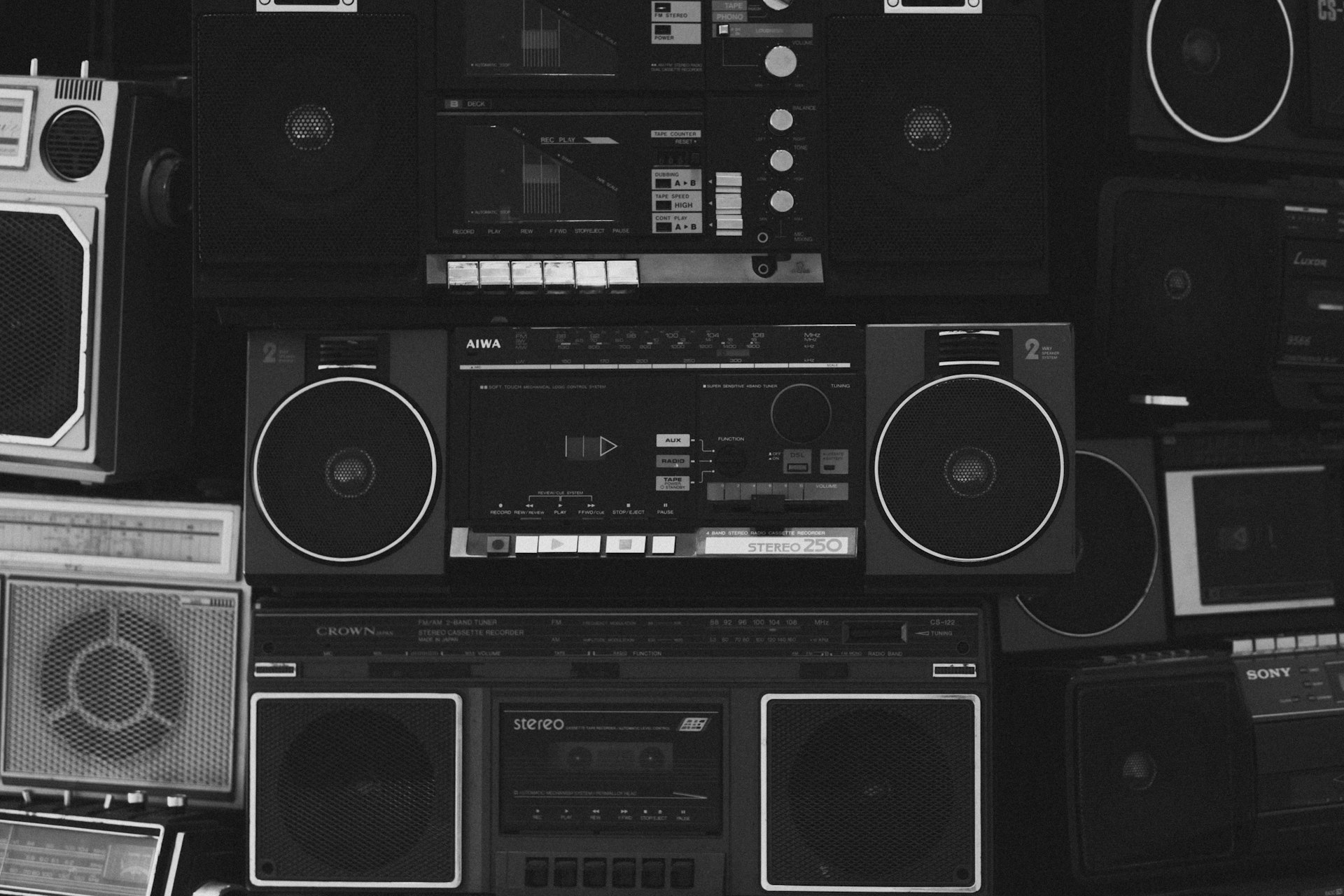 A wall full of boomboxes and electronic equipment
