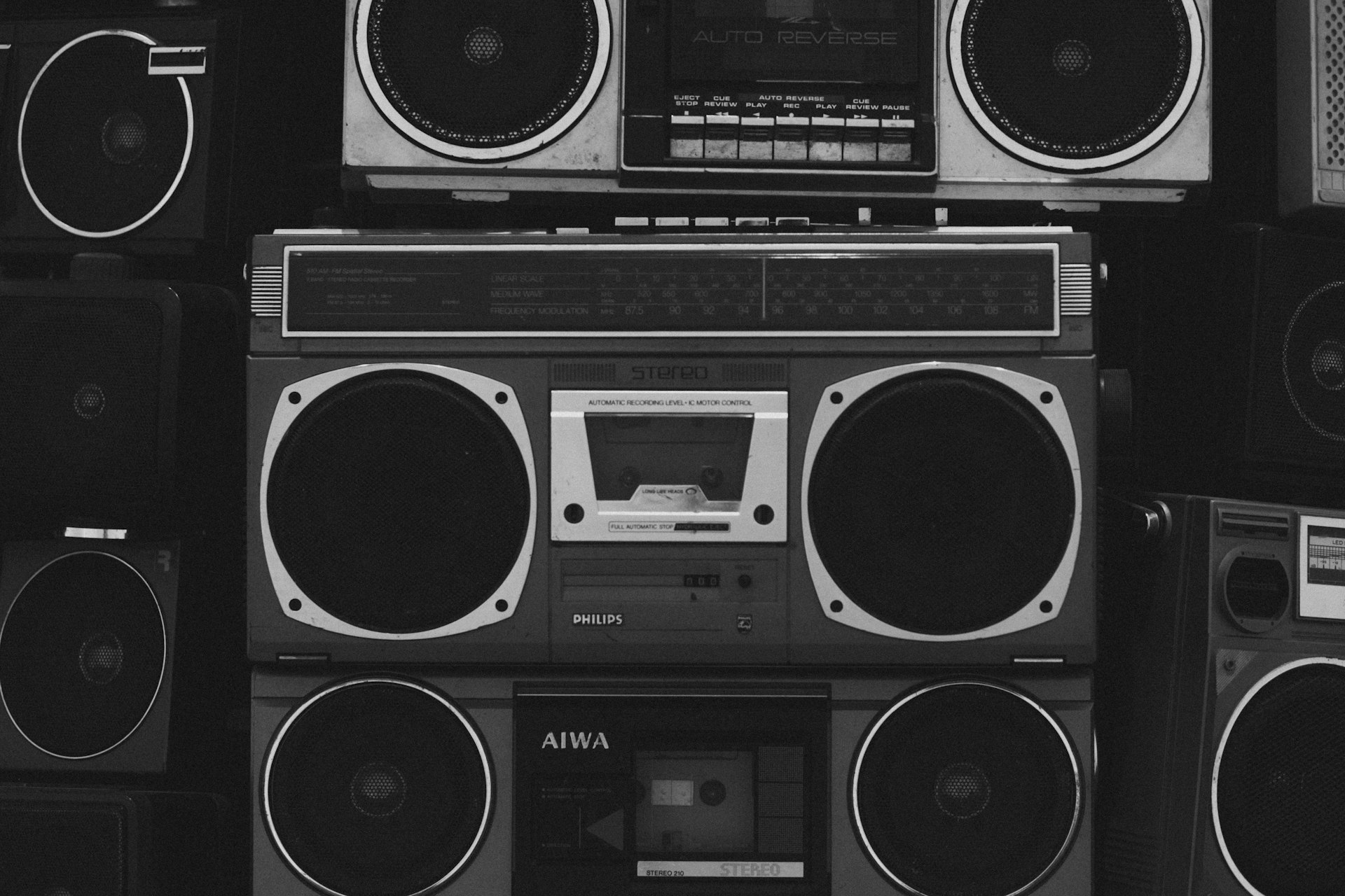 A bunch of boomboxs that are stacked on top of each other